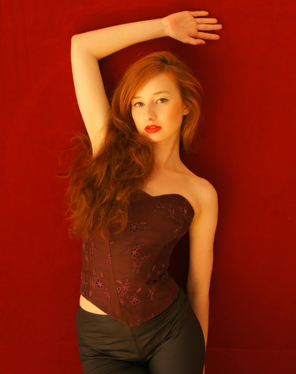 a woman with red hair posing in a black top