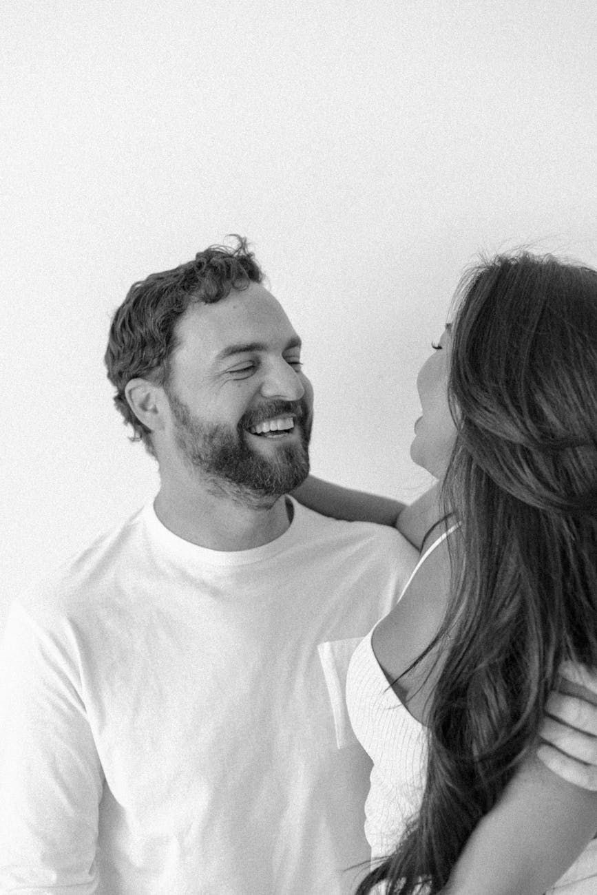 a man and woman are smiling while standing next to each other