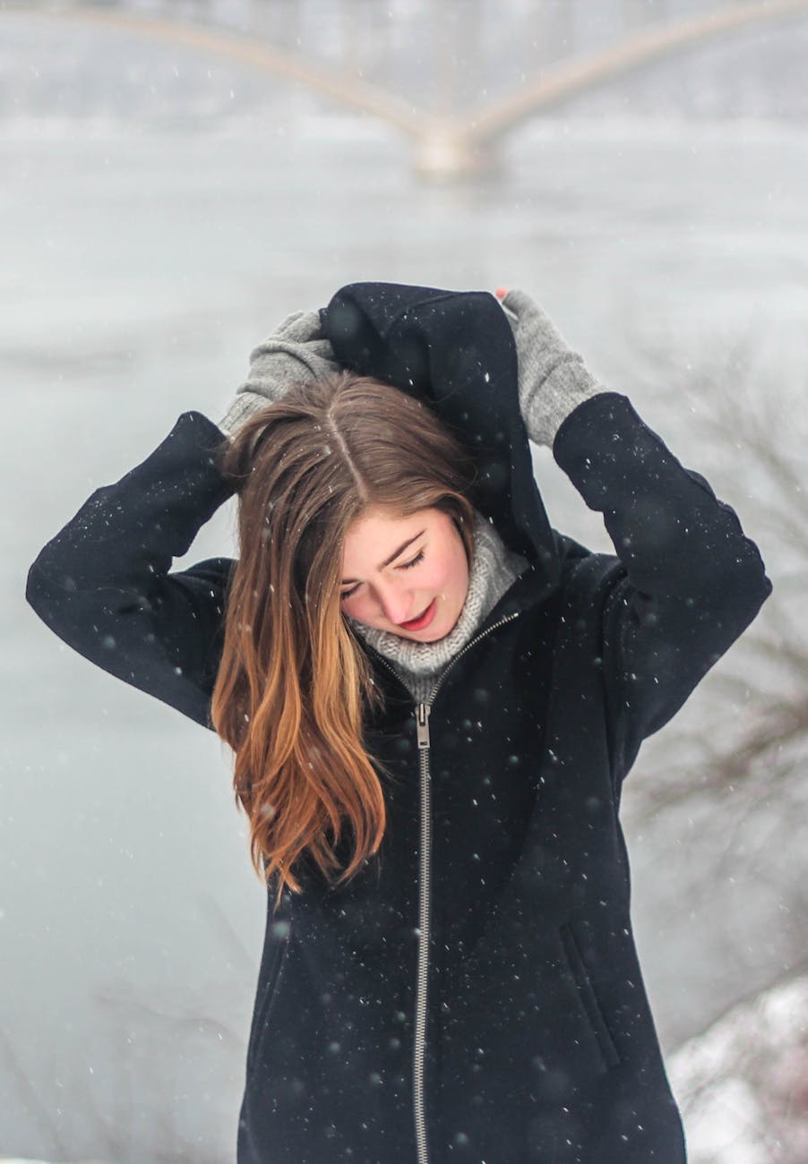 Winter Hydration: Battling Dry Kansas Air at Just For Hair 1 woman grabbing the hood of her hoodie