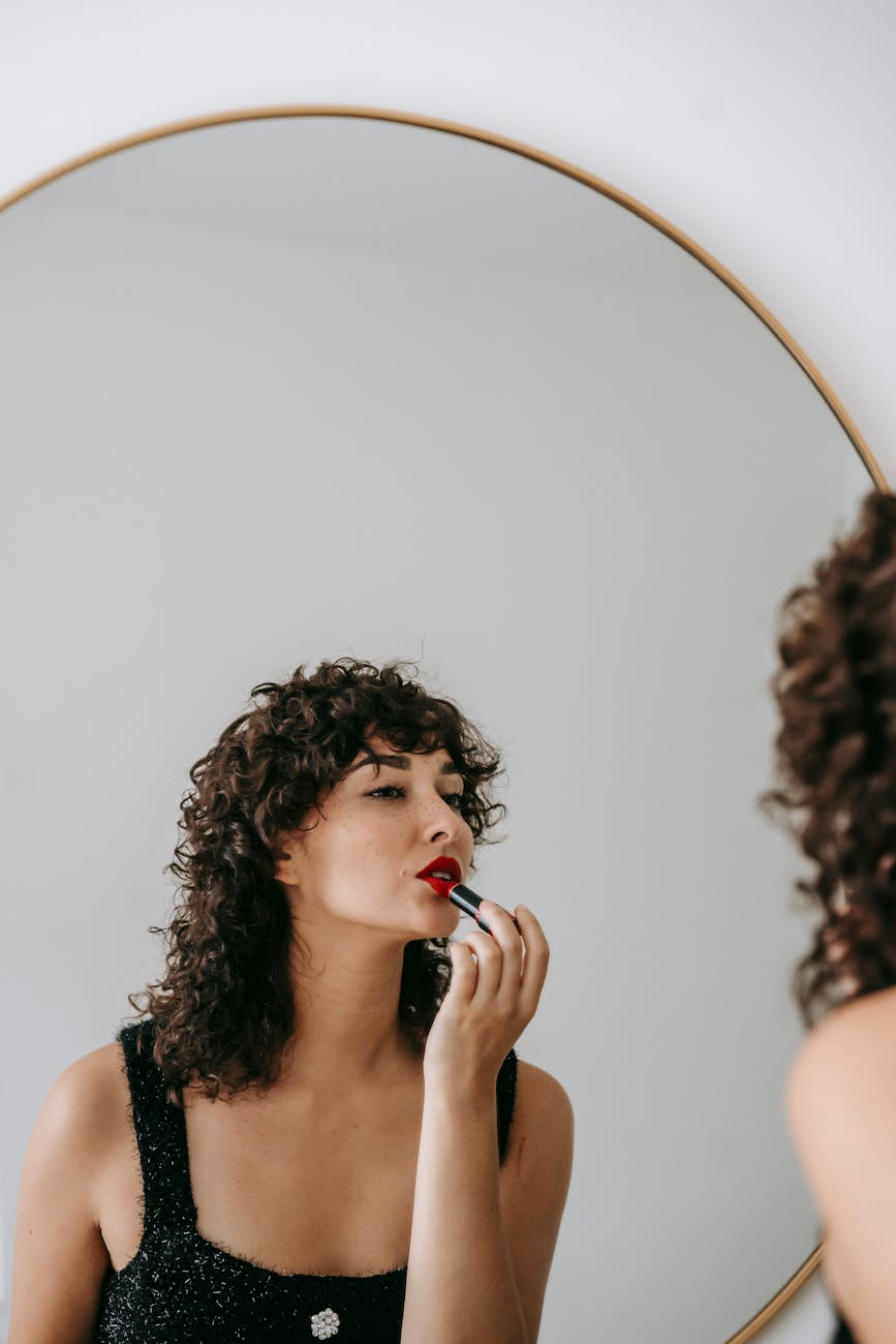 Admiral: Navigating the Heights of Luxury at Just For Hair 1 photo of woman applying red lisptick