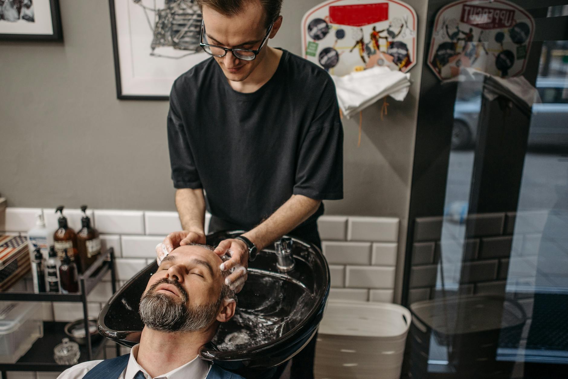 Brassy No More: The Power of Purple Shampoo 1 a barber shampooing a client
