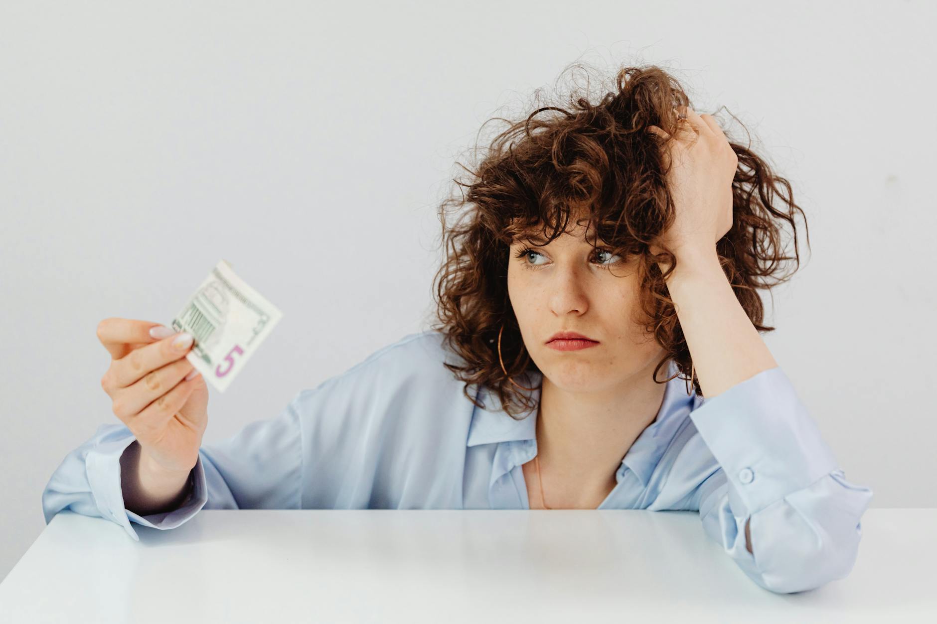 Money Piece: Framing Your Face with Light at Just For Hair 1 curly haired woman holding a paper money