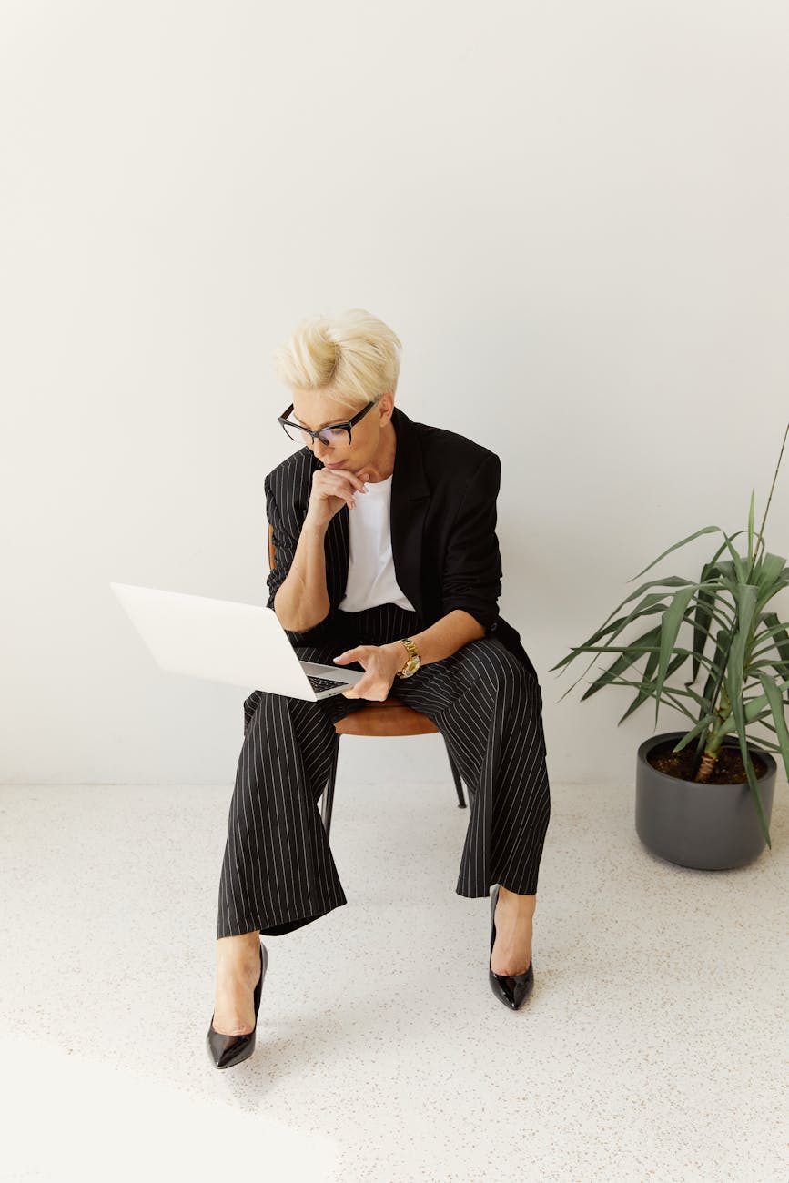 woman in black blazer and pants sitting on chair