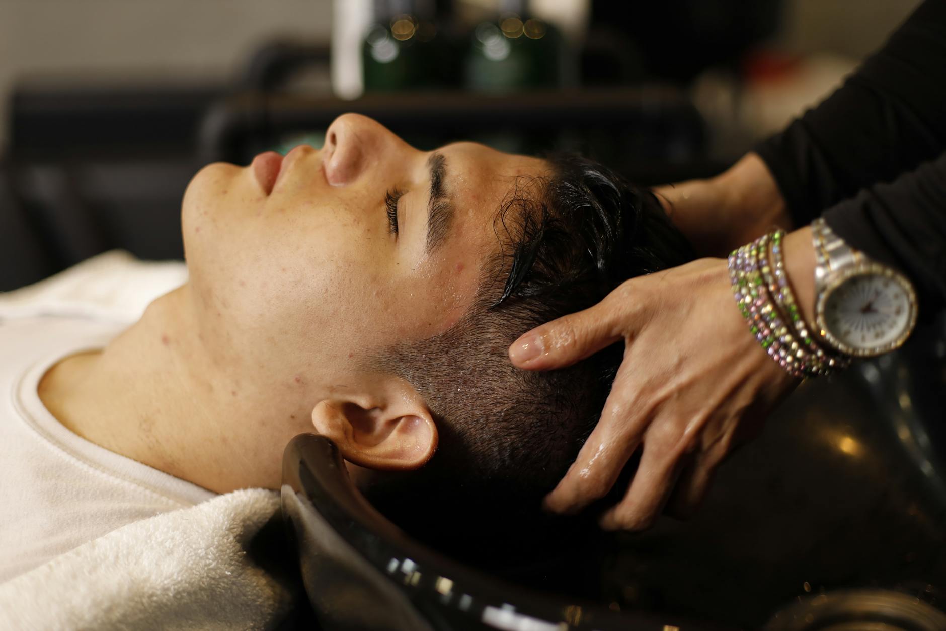 Serenity – Peaceful Hair Spa: A Sanctuary for Your Scalp at Just For Hair 1 a man getting his hair washed by a hairdresser