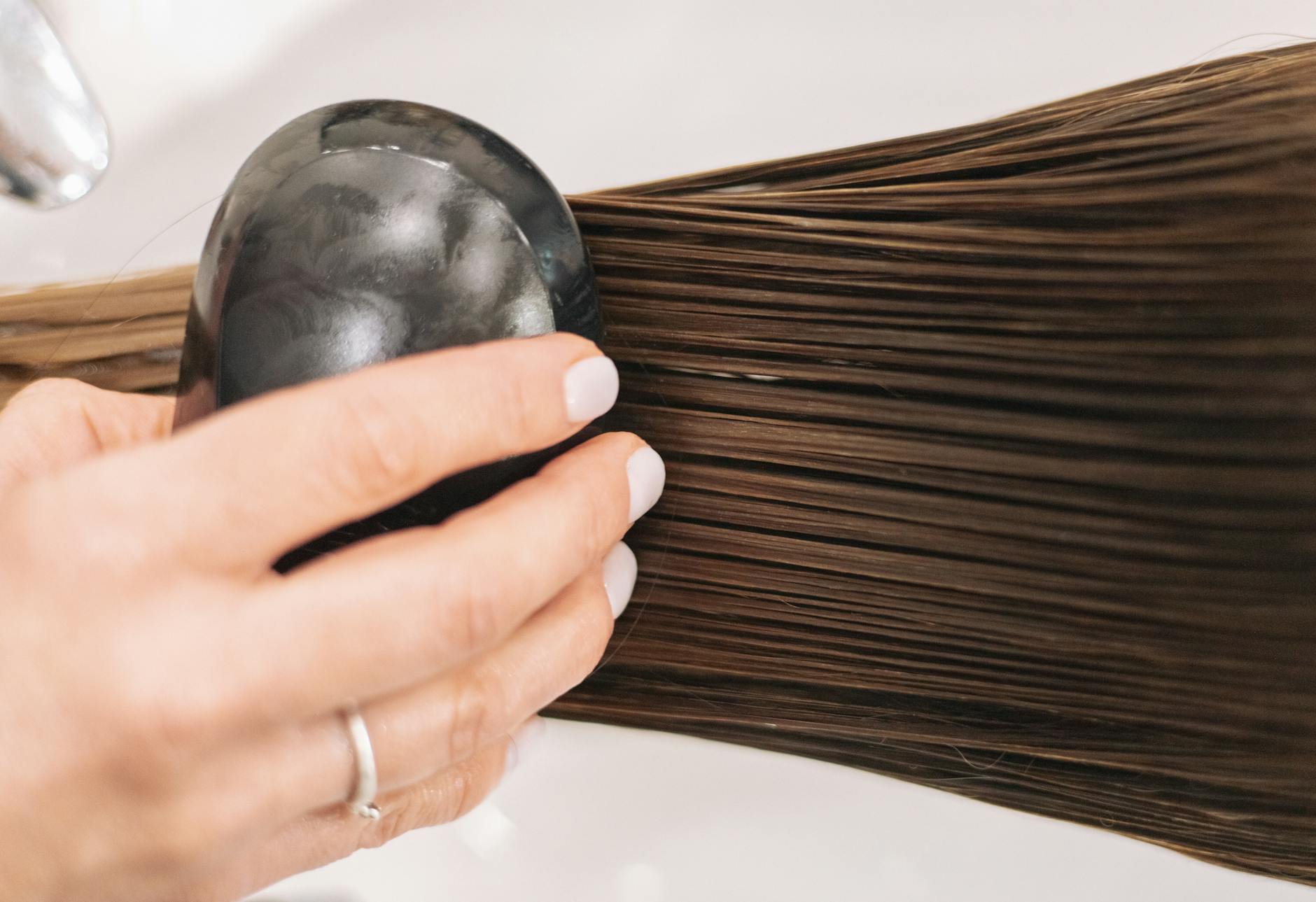 woman hand holding brush and brushing hair