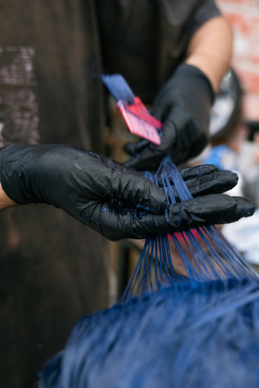 hairdresser wearing gloves dyeing hair blue