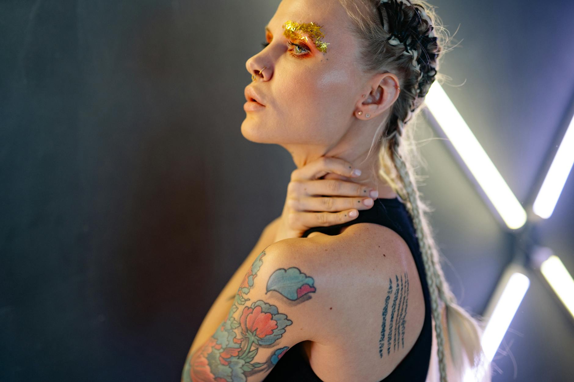 Sparkle – Glitter Hair Services: High-Definition Brilliance at Just For Hair 1 a person with flower tattoo and gold glitters on eyebrow
