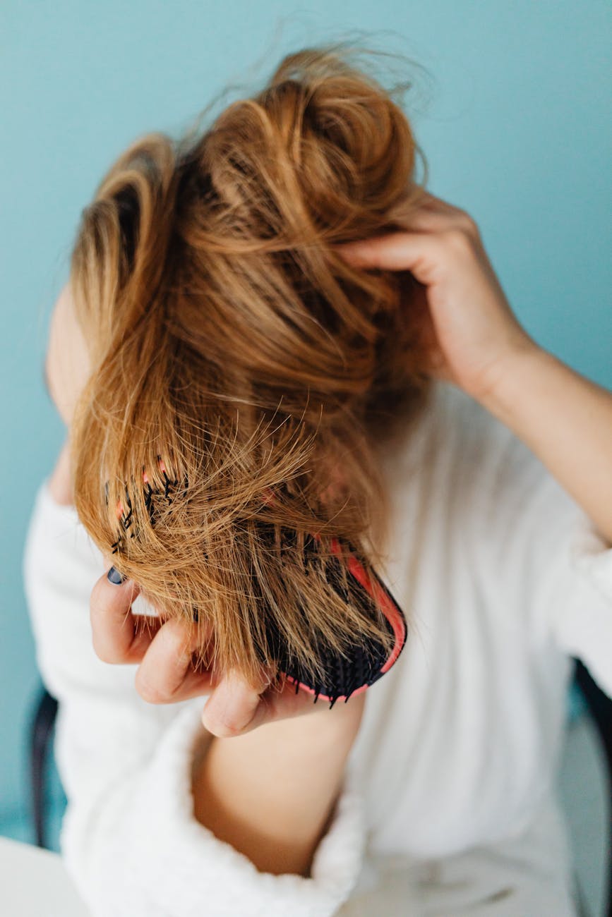Bounce – Bouncy Blowouts: High-Volume Glamour at Just For Hair 1 a woman brushing her hair