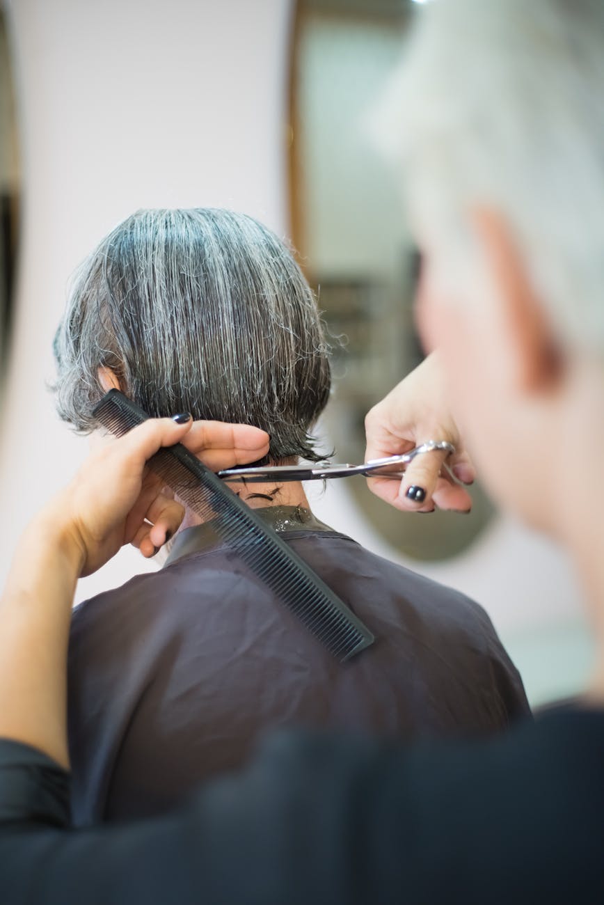 Gravity-Defying Style: Short Layered Haircuts for Maximum Volume 1 person cutting hair with scissors