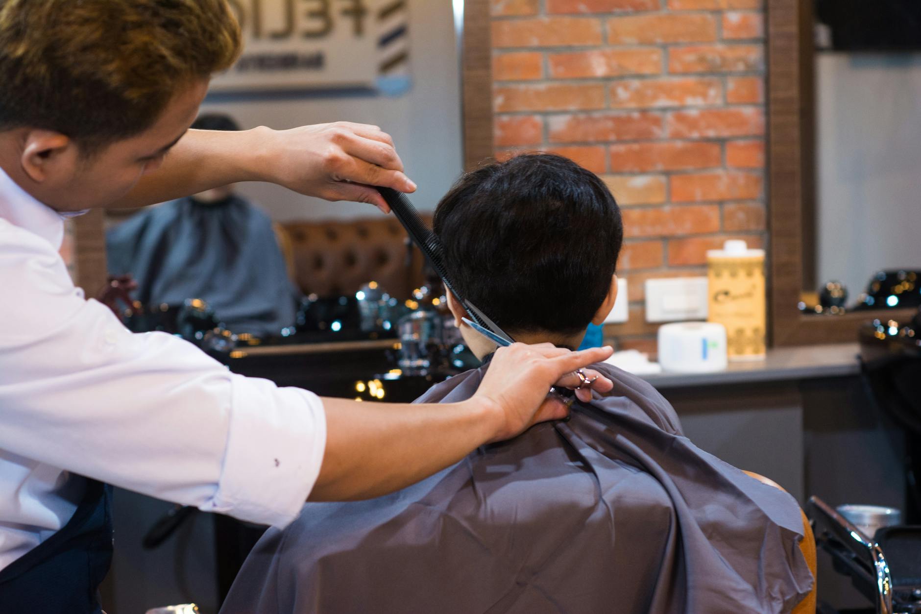 The Precision Cut: 2026 Men’s Grooming for Sharp, Stylish Looks 1 barber cutting client hair in saloon