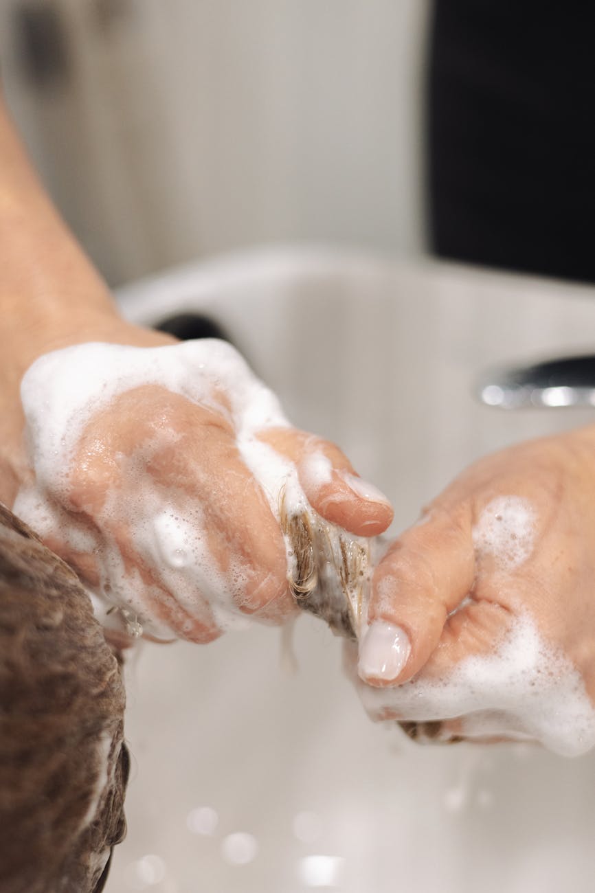 Deep Renewal: The 2026 Hair Spa Experience at Just For Hair 1 hands of woman washing hair