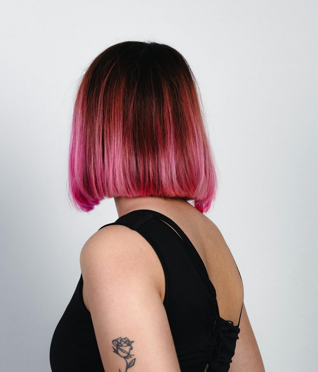 pink bob hairstyle with rose tattoo from behind