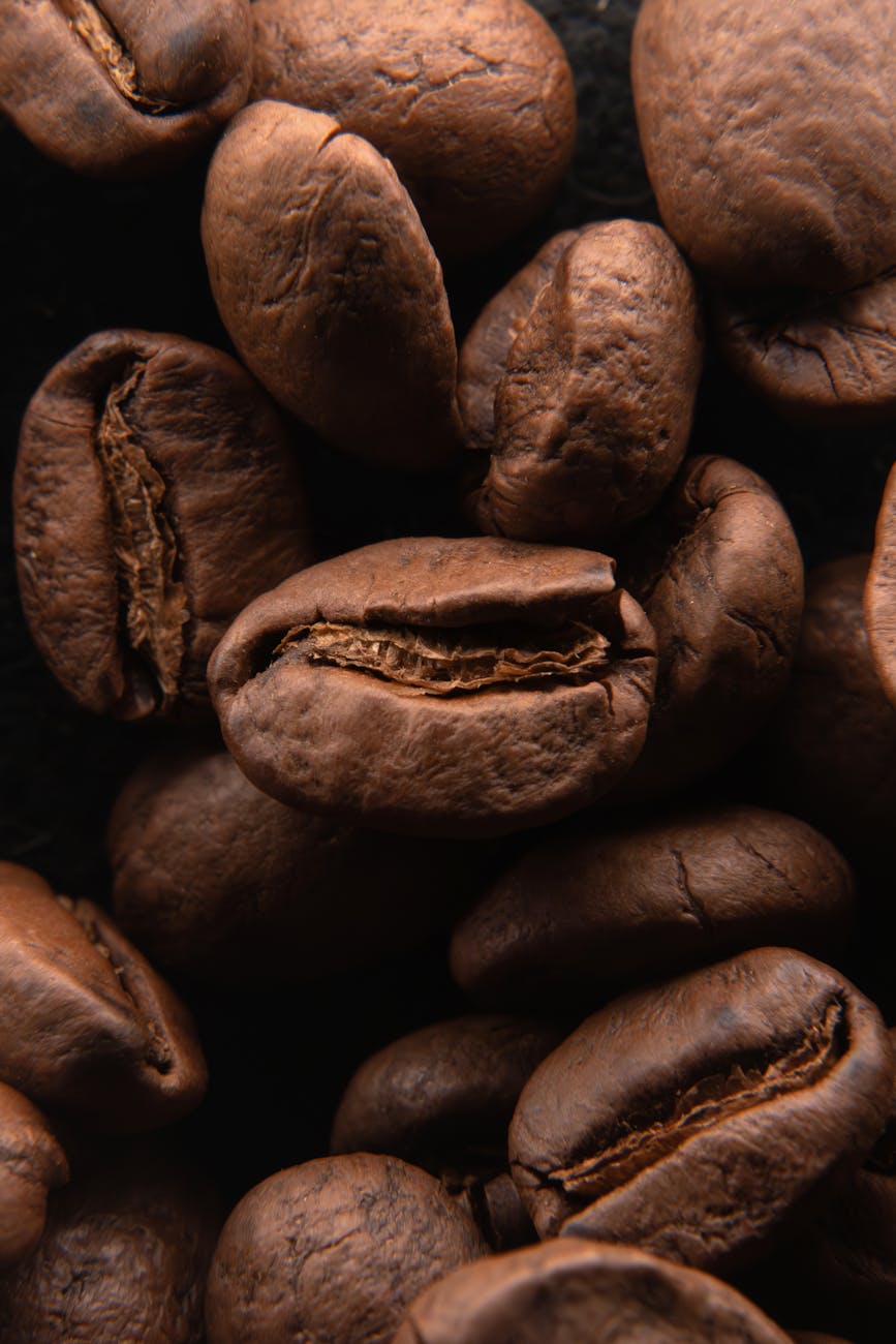 close up of roasted coffee beans on dark background