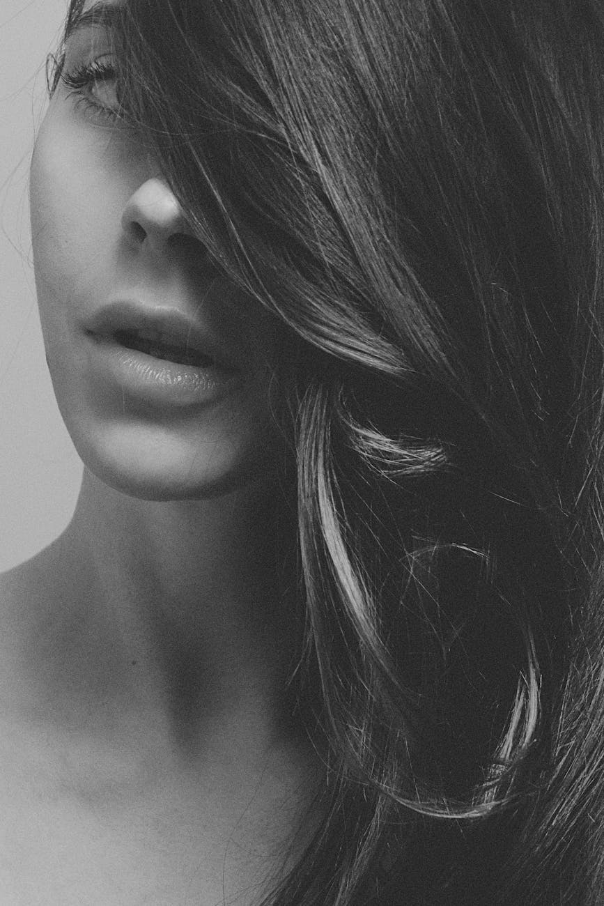 grayscale photography of a woman hair covering face