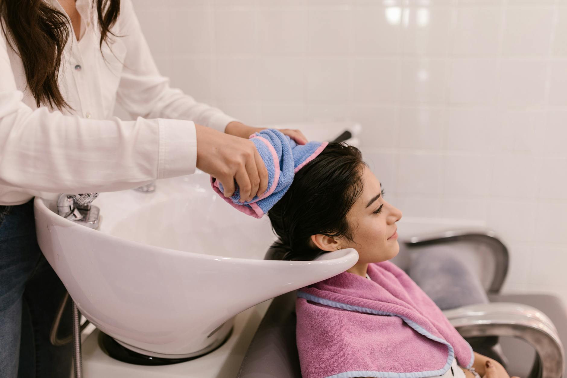 Deep Renewal: The 2026 Hair Spa Experience at Just For Hair 1 a woman sitting near the sink