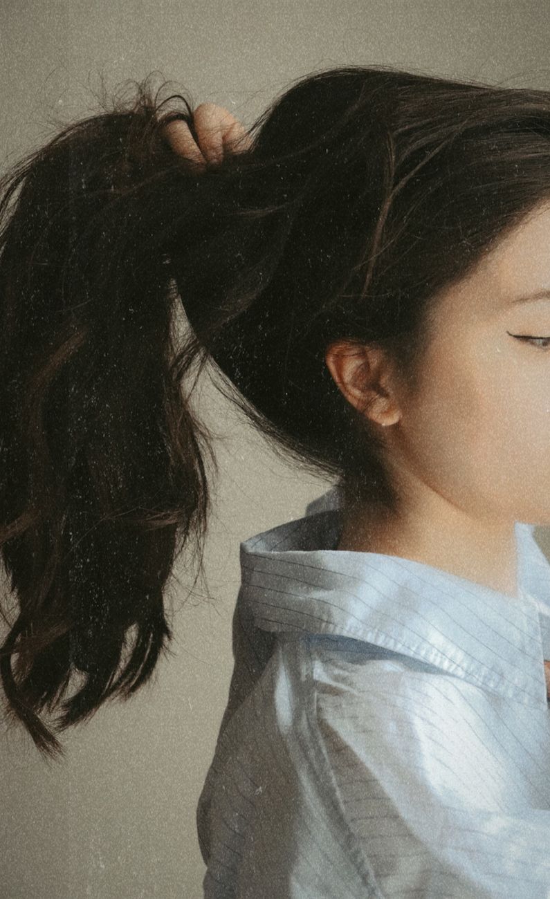 woman in white and blue stripe shirt holding her hair