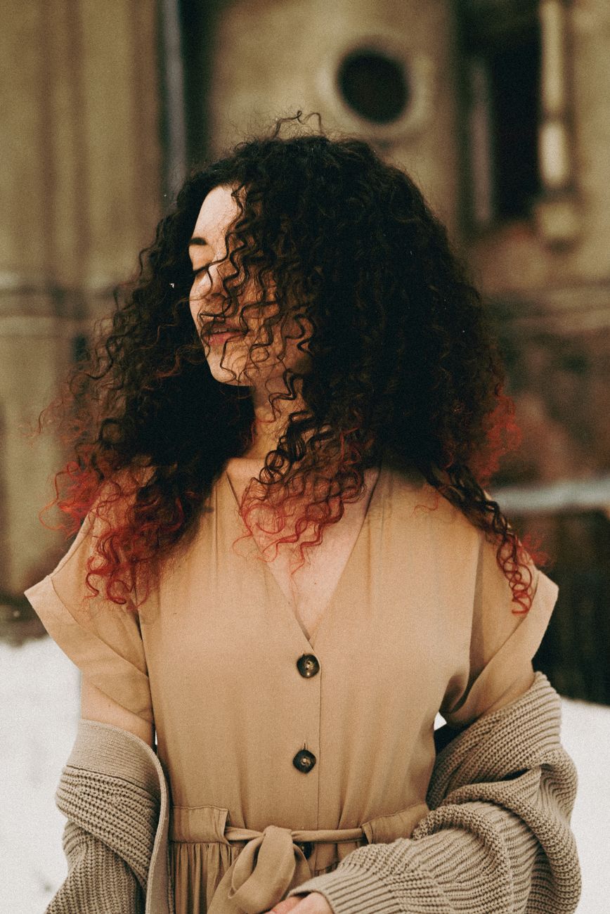 Ribbon Highlights vs. Color Melts for Coily Hair Texture 1 woman with curly hair