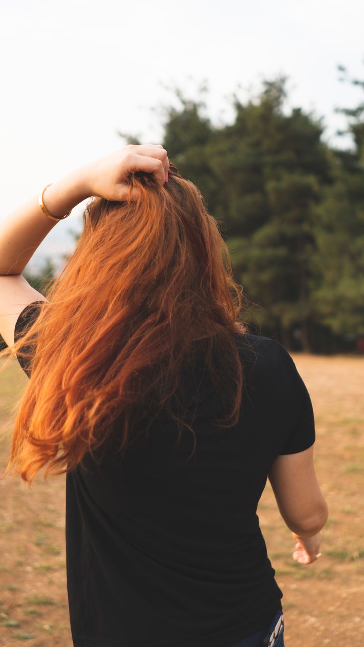 back view of a redhead woman in black shirt
