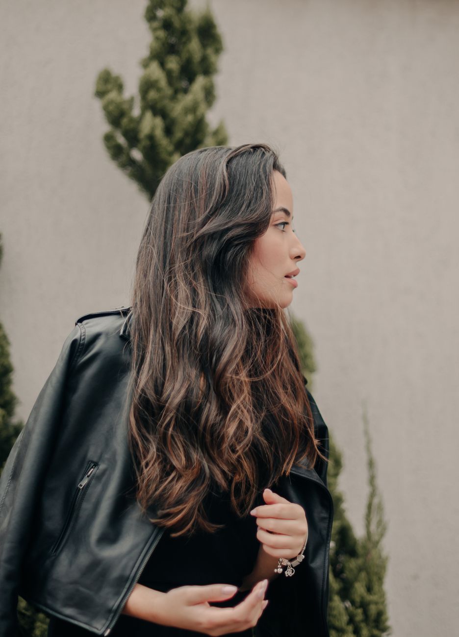 Cutting Waves: How We Cut Hair Differently After a Perm 1 photo of a young brunette in a leather jacket standing outside