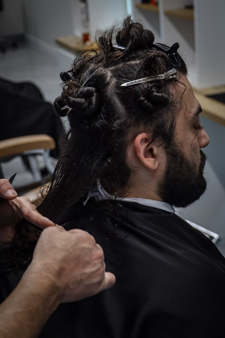 From Straight to Curls: A Step-by-Step Transformation Story 1 man getting hair styled in a salon