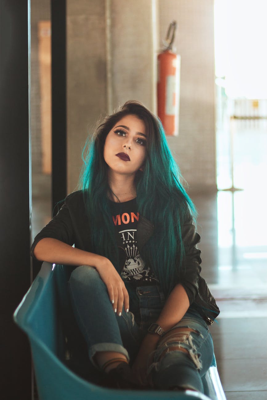woman in crew neck t shirt sitting on blue chair