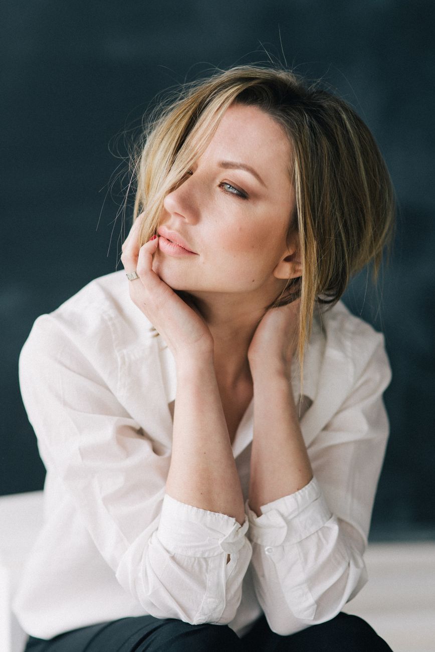 blonde female posing with her hair covering the half of her face