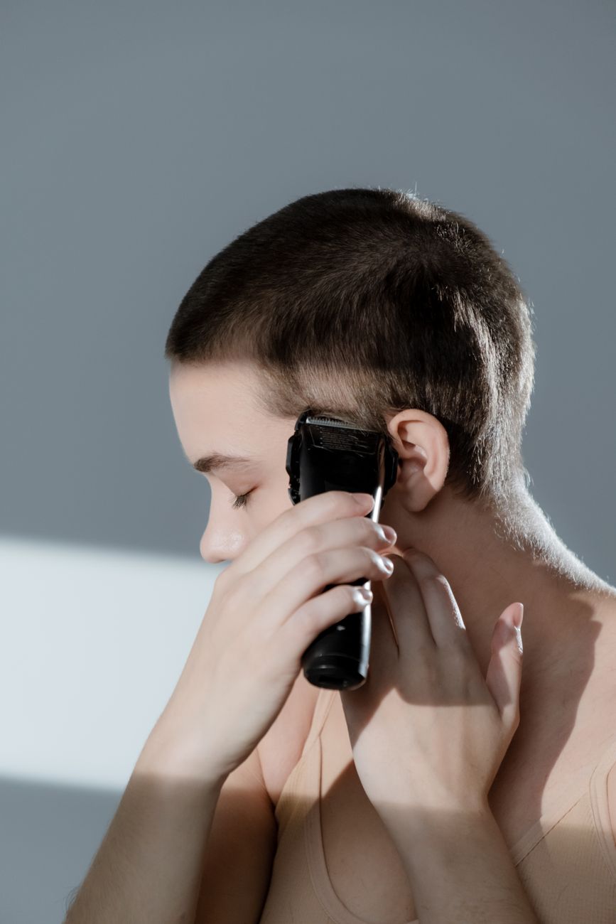 close up shot of a woman trimming her hair with a razor