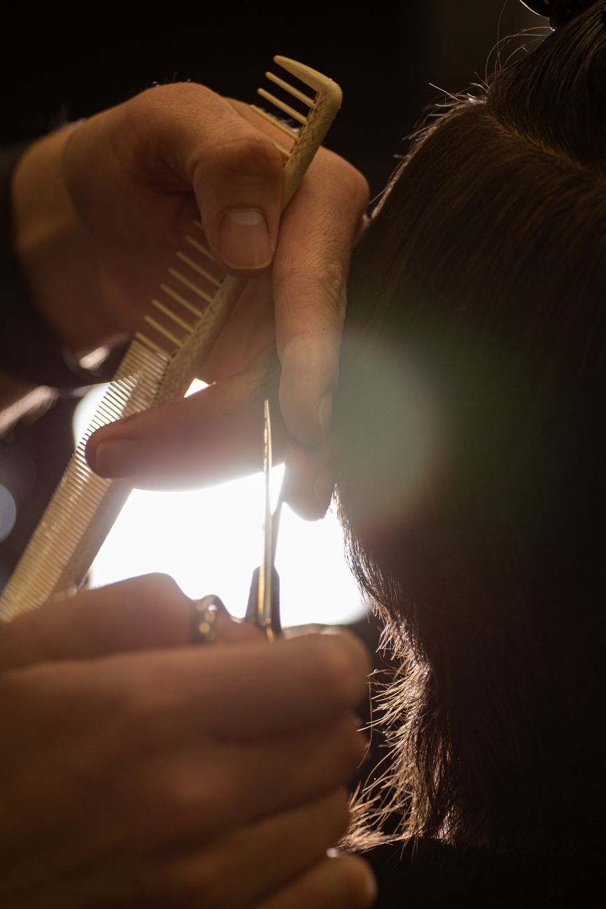 Wispy Texturizing vs. Point Cutting for Delicate Hair Types 1 person cutting hair in close up photography
