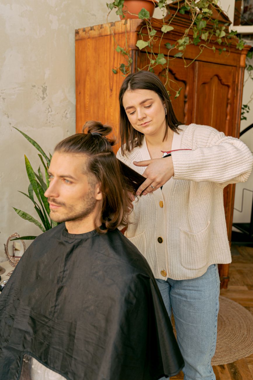 The Resurgence of the Modern Shag Cut in Kansas 1 a woman giving a haircut to a bearded man