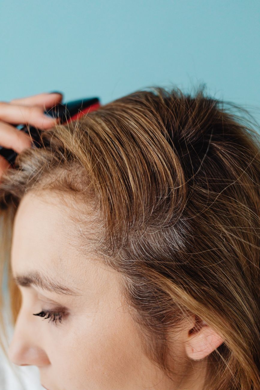 face of a woman brushing her hair