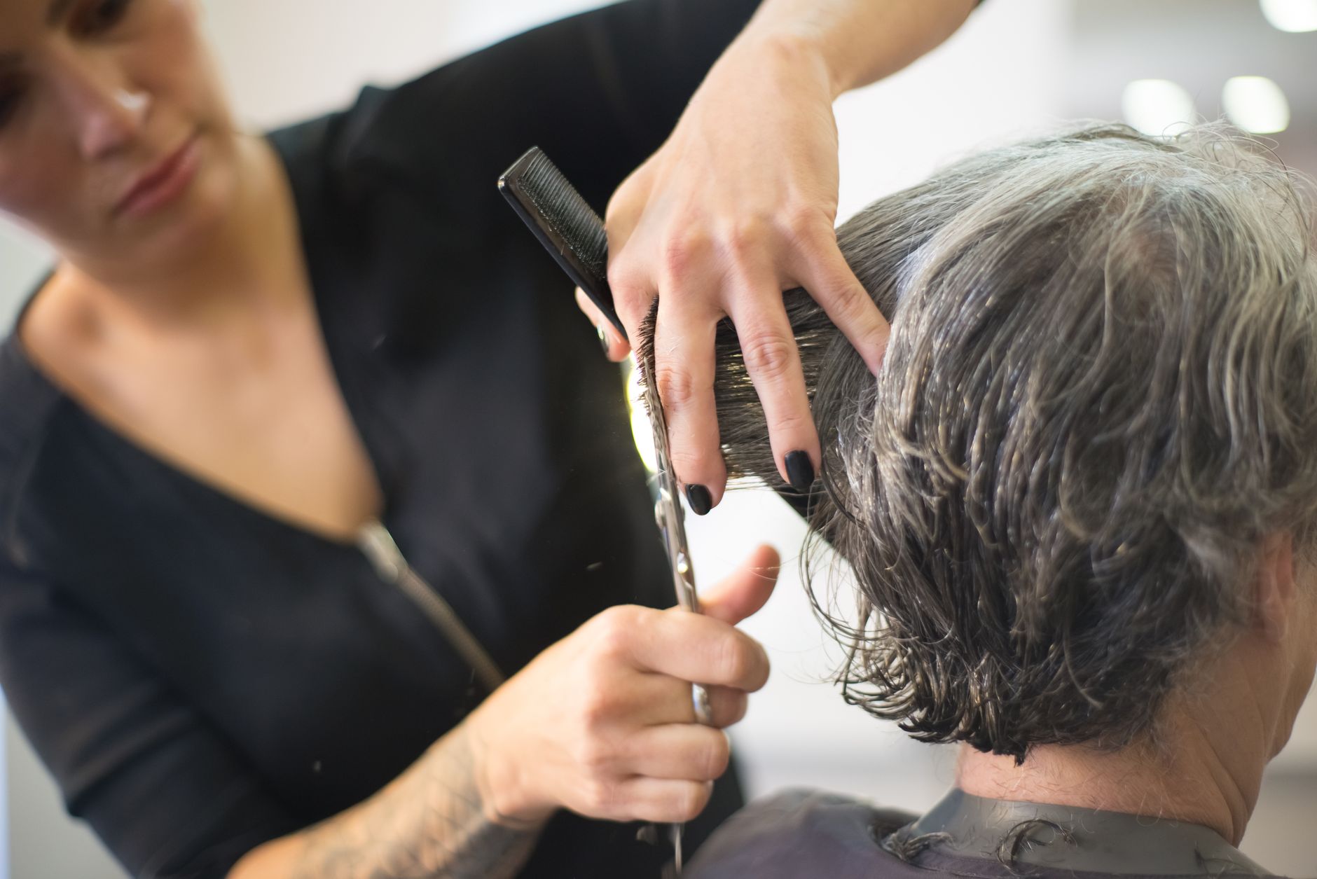 The Anatomy of a Precision Haircut at OP Hair Salon 1 woman in black nails cutting the hair of the person