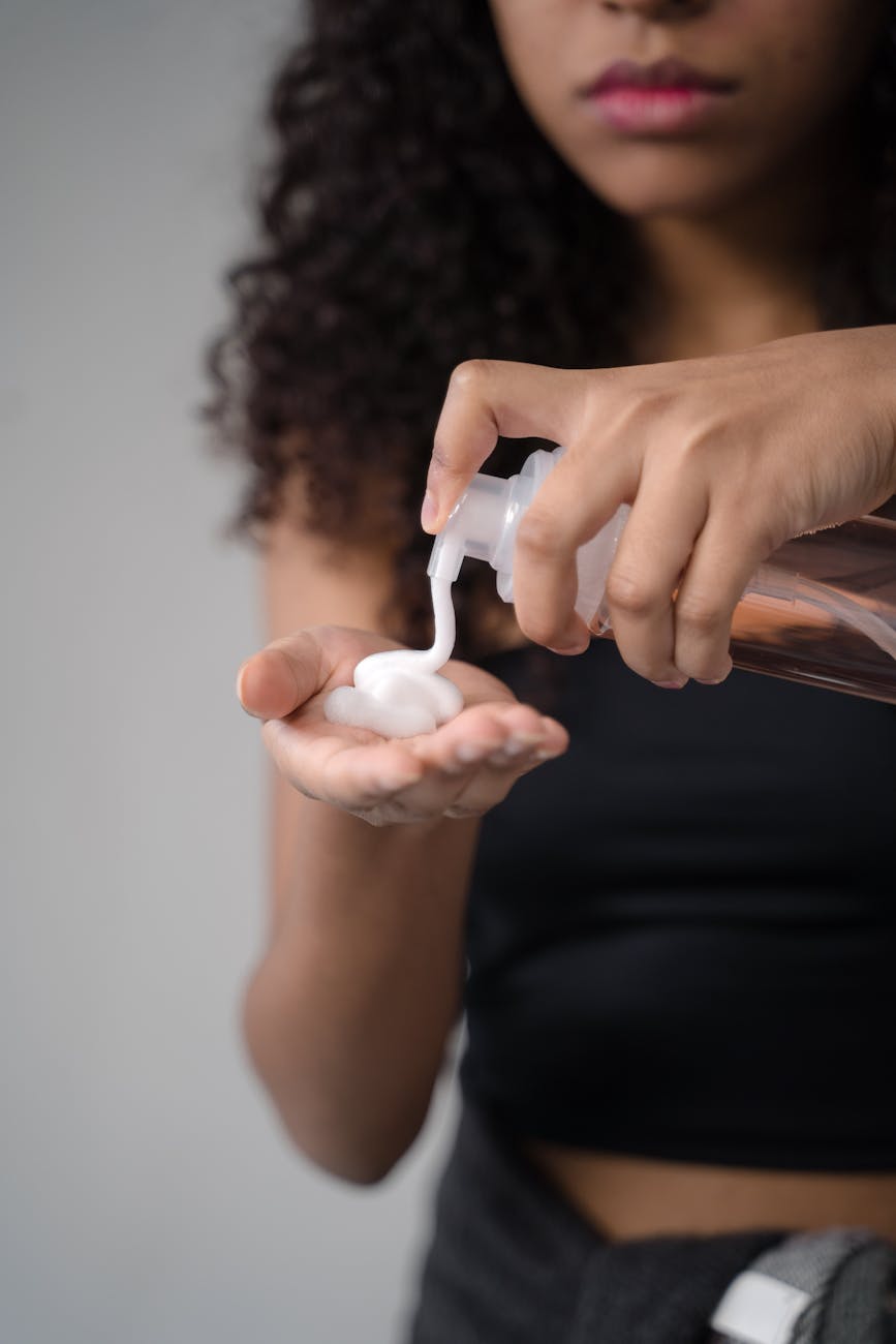Moisture for Curls: The Best Products for Your New Perm 1 a girl putting cream on hand with a pump bottle