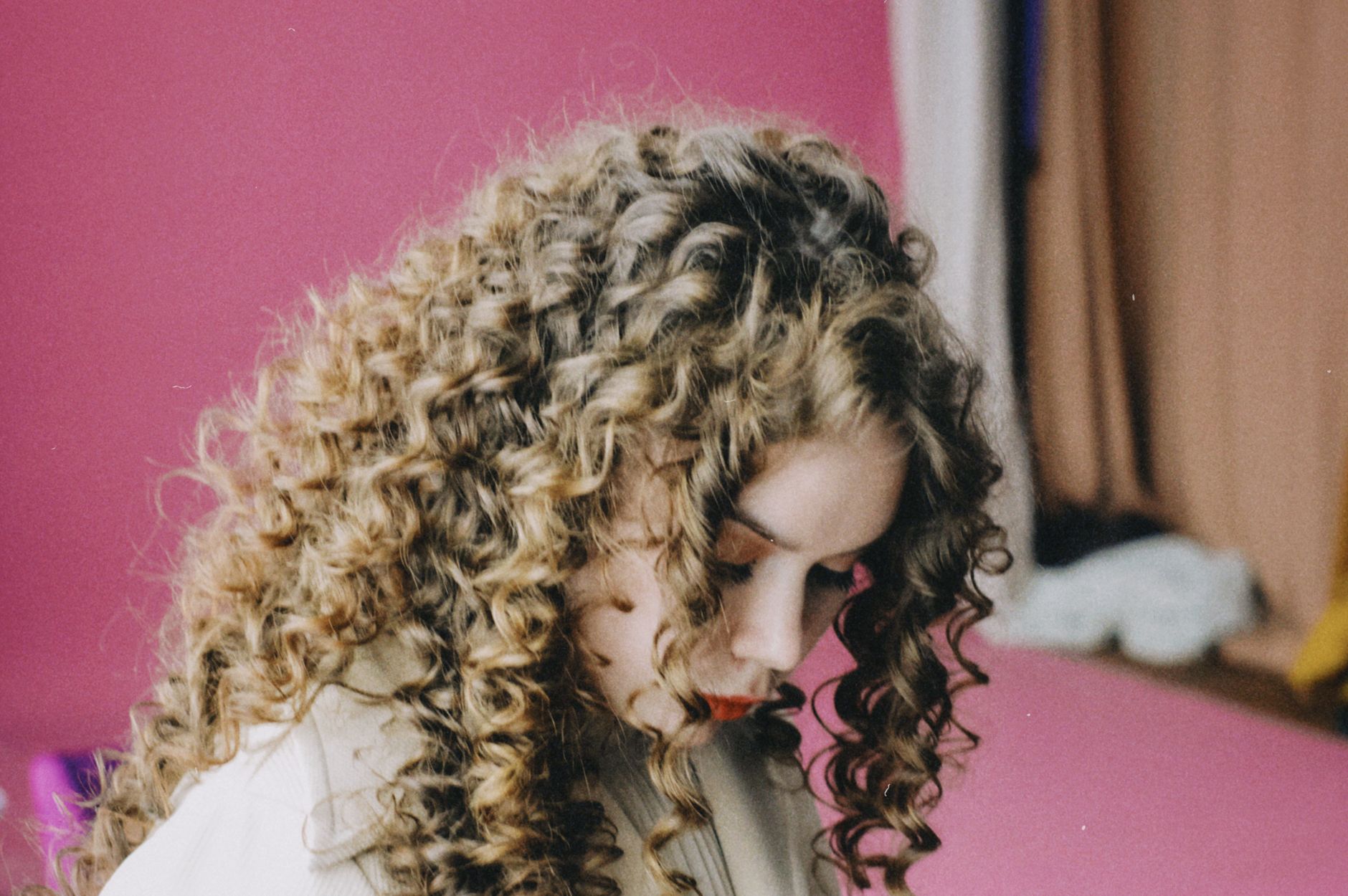 photo of a woman with curly hair looking down