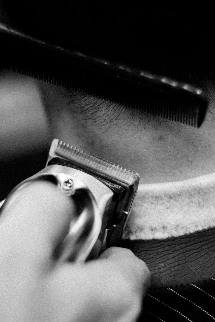 Channel Cutting: The Texturizing Method for Effortless Air-Dried Styles 1 grayscale photo of person holding a comb and a razor to cut a someone s hair