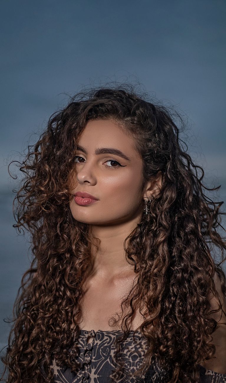 Digital Perms vs. Cold Perms: Which Thermal Option Fits Your Lifestyle? 1 a woman with curly hair and red lipstick