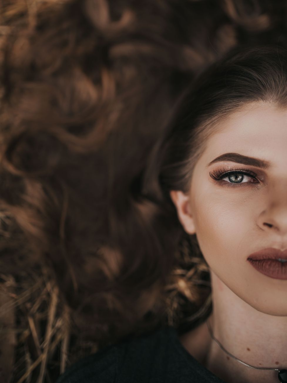 half face portrait of a young woman lying on the ground