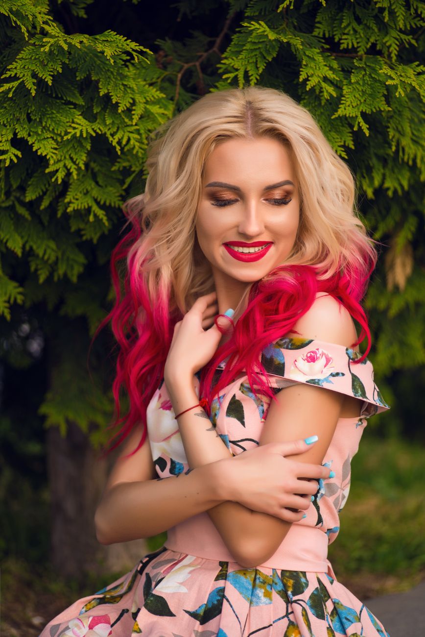 a beautiful blonde woman with pink hair posing for a photo