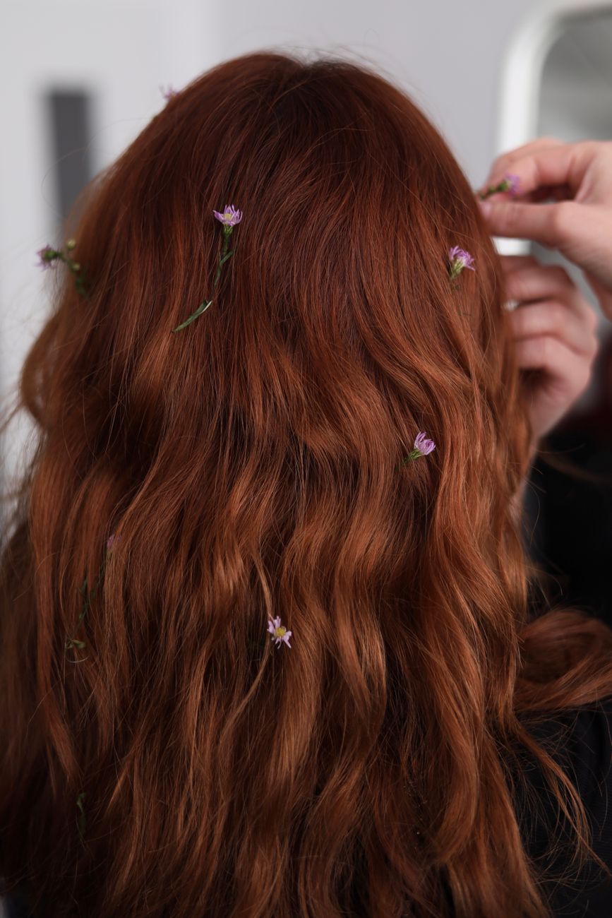 The Wavy Hair Awakening: How to Uncover Hidden Waves in Your Heavy Layers 1 small flowers petals in redhead woman hair