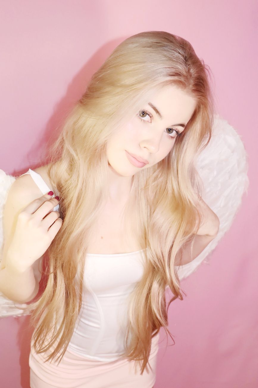 beautiful blonde angel on soft pink background