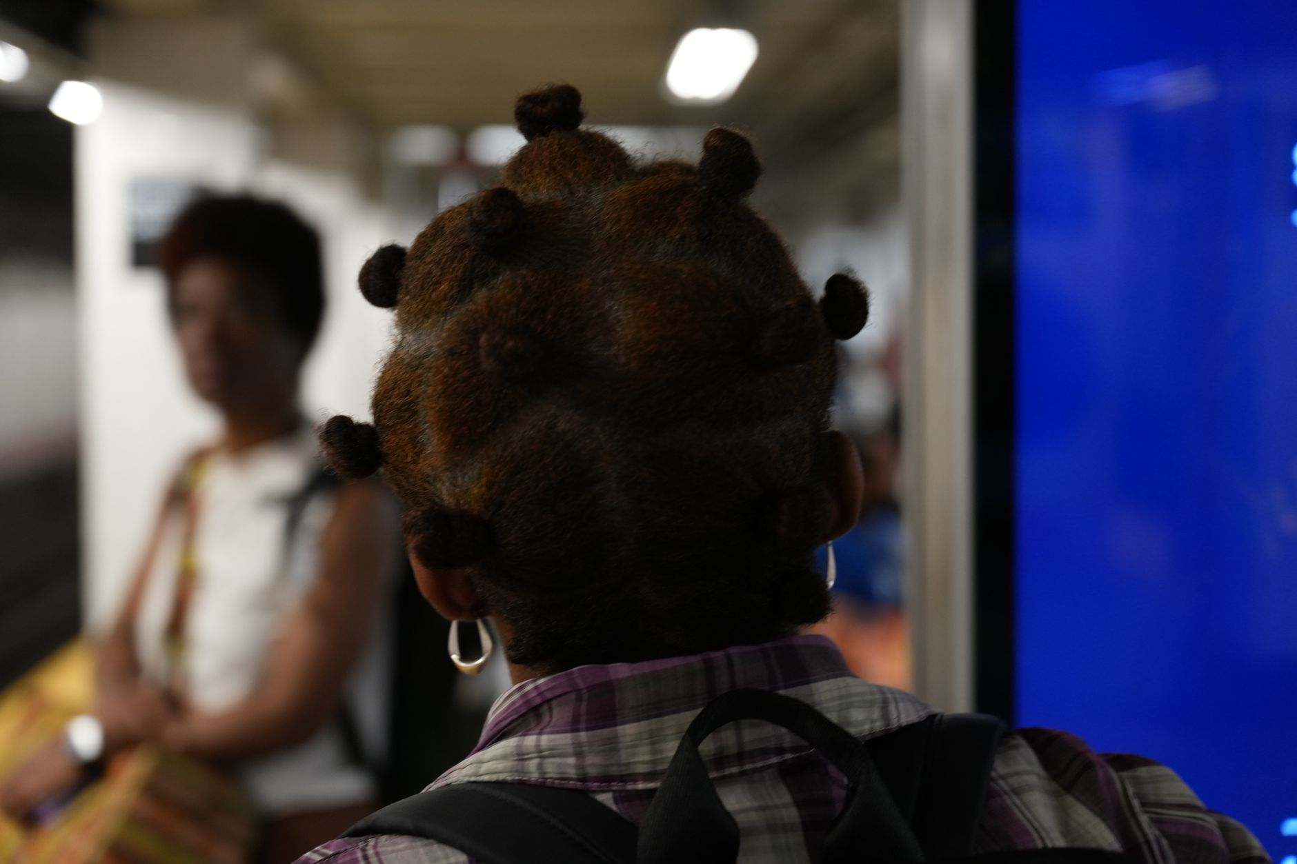 Bantu Knots: Combining Traditional Textures and Modern Style Accents 1 back view of person in subway with intricate hairstyle