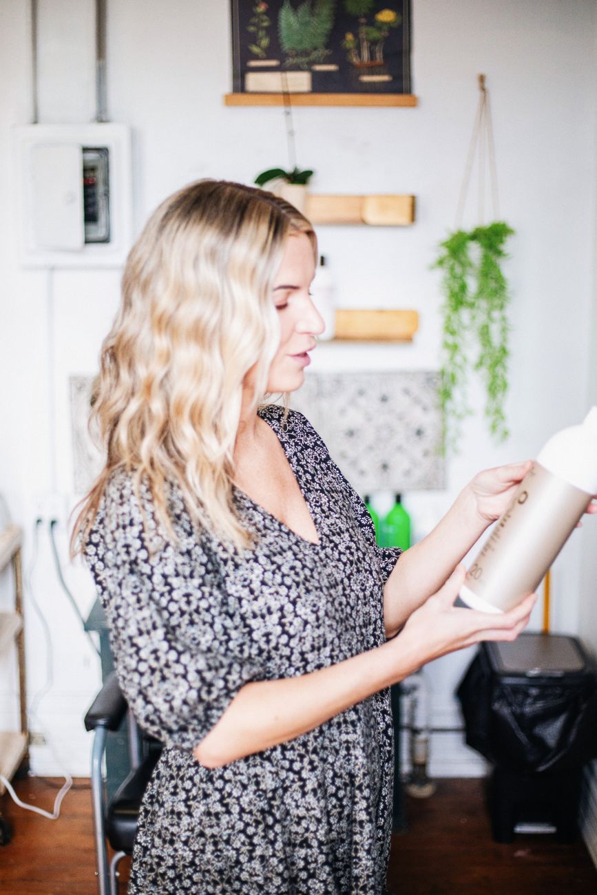 elegant hairstylist examining product in salon