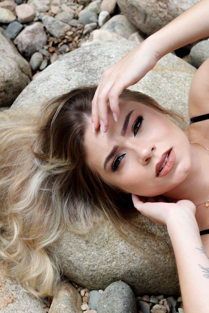 woman relaxing on rocks by the beachside