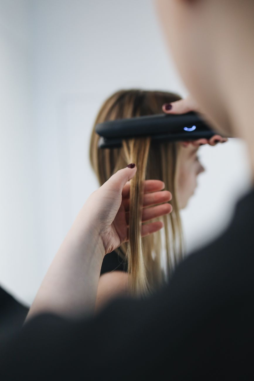 Straightening Heavy Coils: Balancing Thermal Realities and Hair Health 1 selective focus photo of person ironing a woman s hair