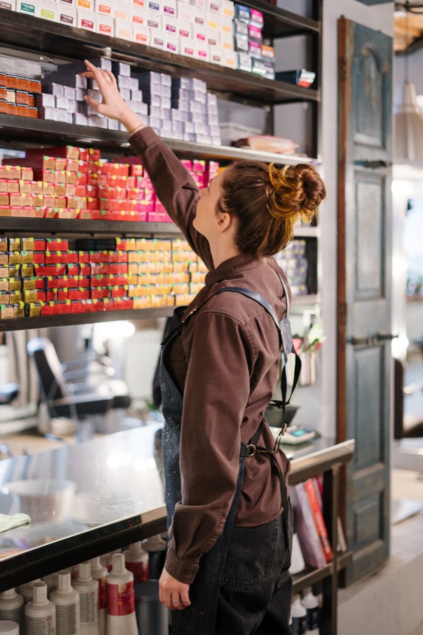 woman in brown jacket standing in front of store