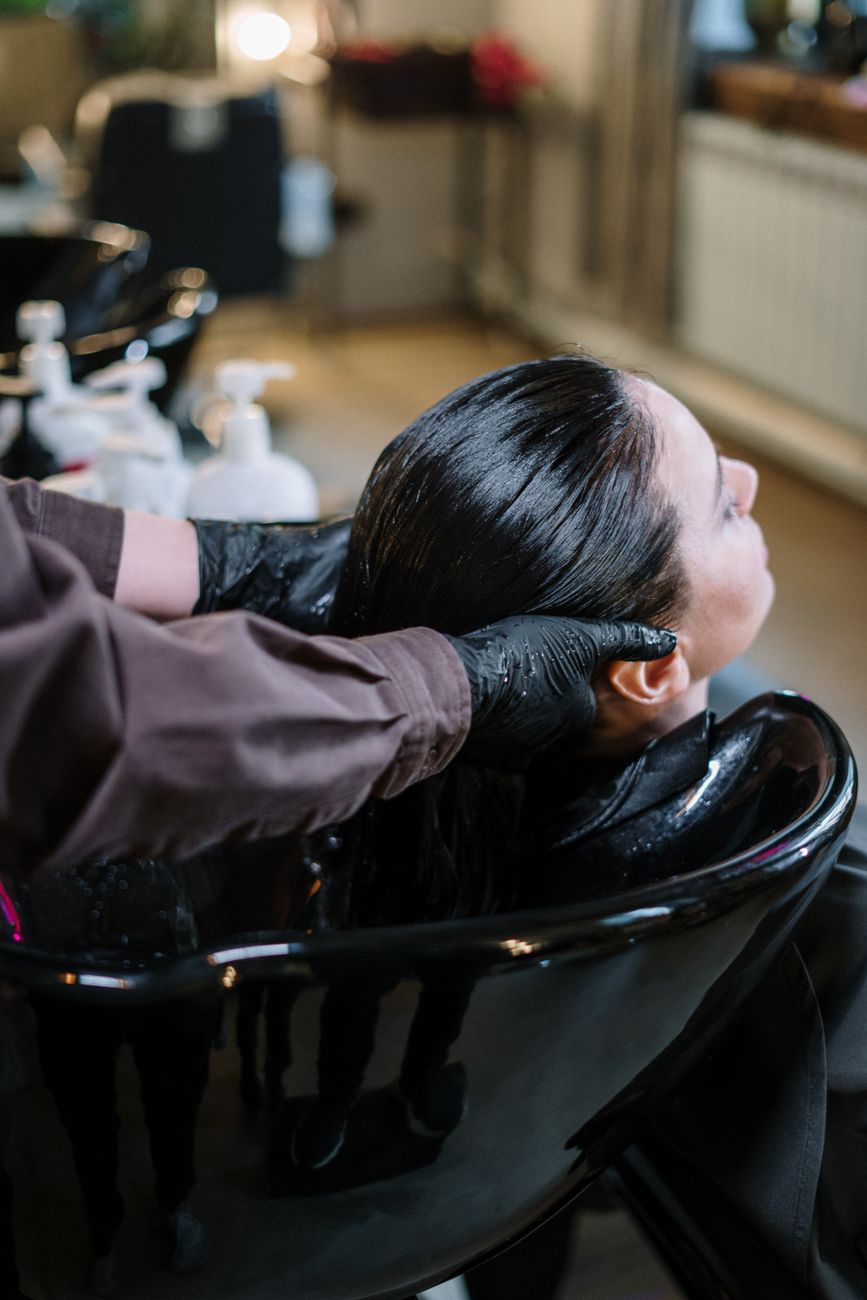 Amino Acid Smoothing: The Formaldehyde-Free Path to Frizz-Free Days 1 woman having her hair rinse