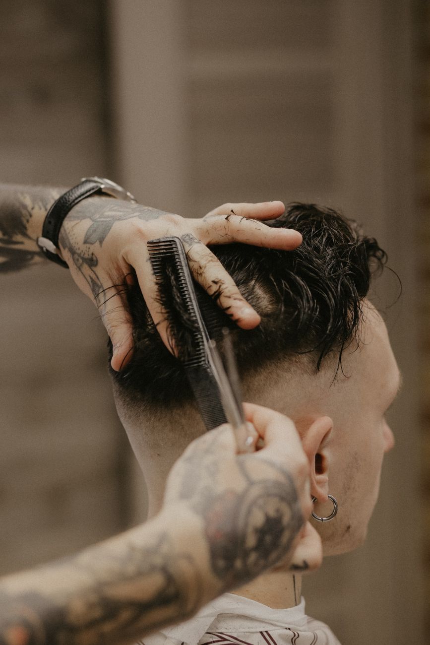 The Buzz Cut Fade: Minimalist Precision Styling for Active Men 1 a man having a haircut