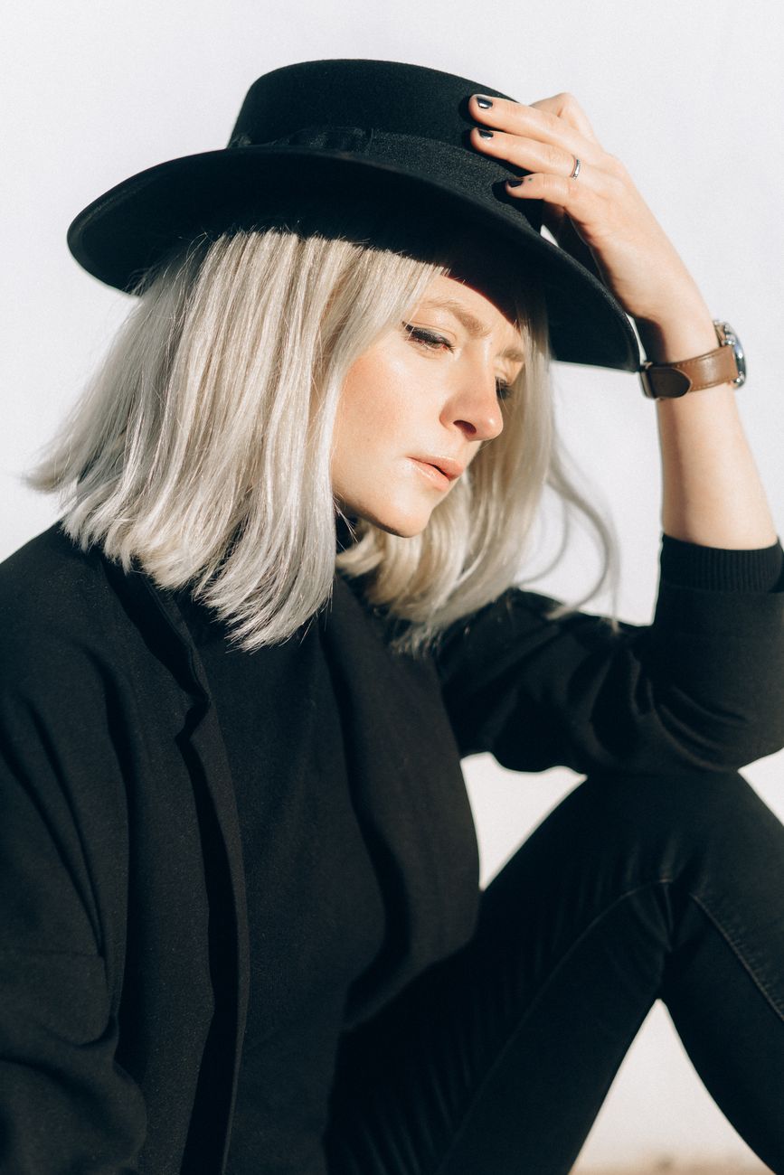 From Black Box Dye to Platinum Blonde: A Realistic Multi-Session Journey 1 woman in black long sleeve shirt and black hat
