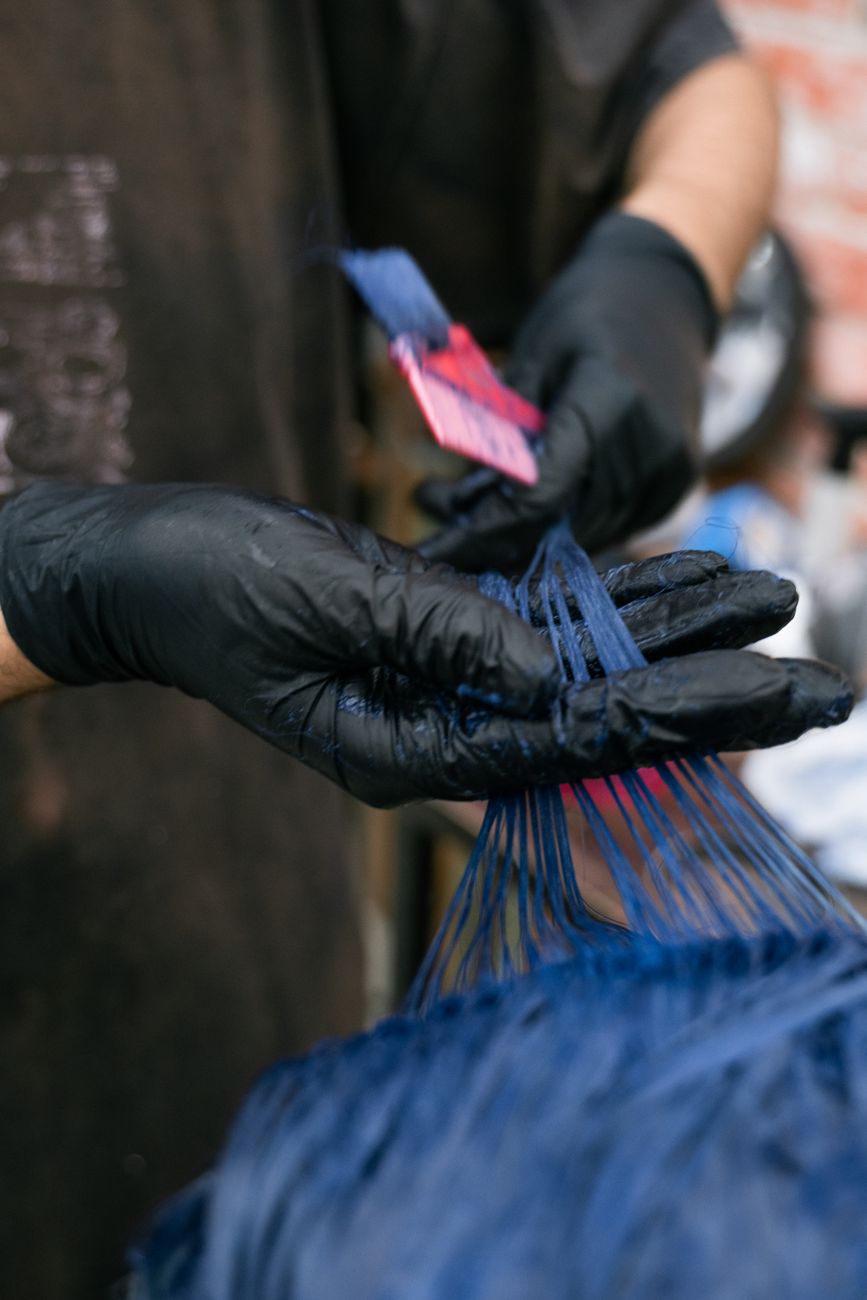 Porosity Balancing Sprays: Creating an Even Surface Prior to Direct Dyeing 1 hairdresser wearing gloves dyeing hair blue