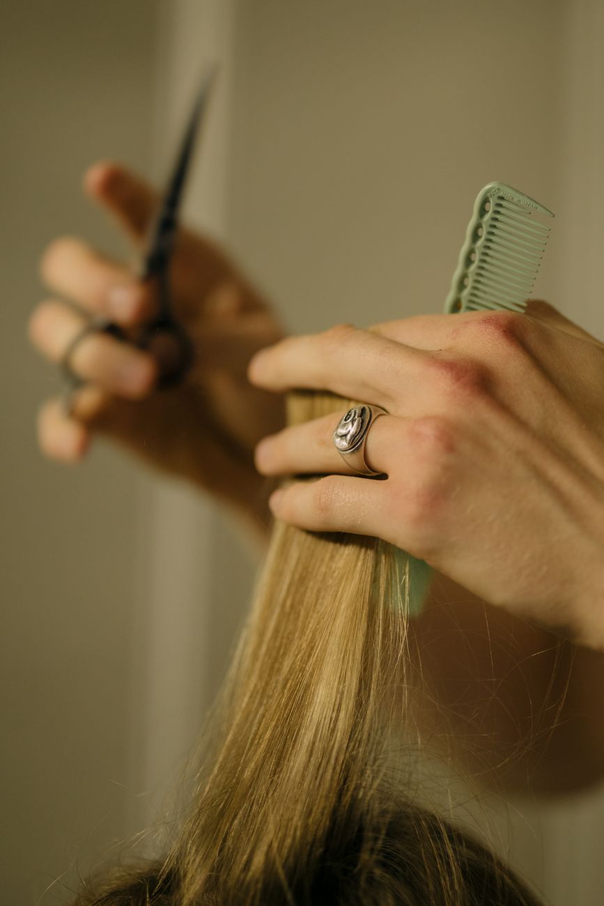 The Ultimate New Year Hair Refresh Blueprint: Stepping Boldly Into Next Season 1 a person holding scissors and green comb