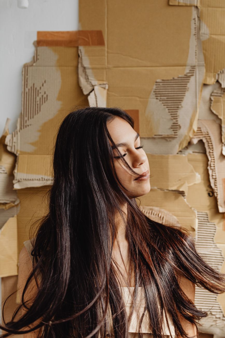 Cold Brew Balayage: Deep Espresso and Warm Amber Tones 1 a young woman flipping her hair